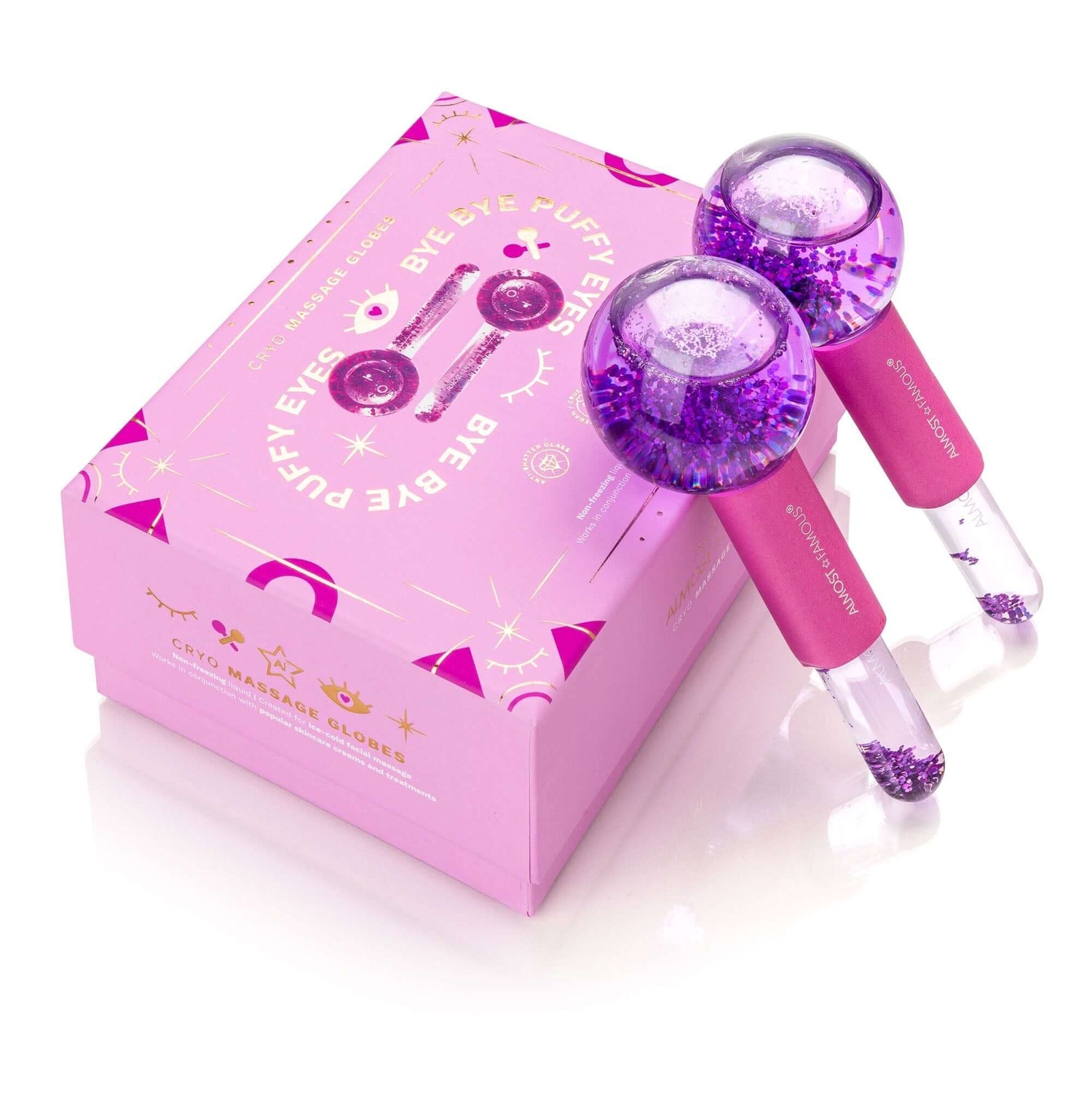 Purple cryo massage globes with pink handles and decorative box, designed for puffy eyes treatments.